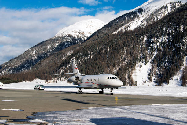 A private jet is ready to take off in the airport of St moritz in the alps switzerland in winter A private jet is ready to take off in the airport of St moritz in the alps switzerland in winter samedan stock pictures, royalty-free photos & images