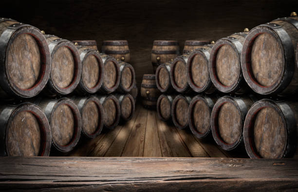 istock Old wooden table top and oak wine barrels. 920332058