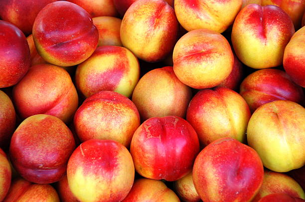 pila di nectarines - nectarine peach red market foto e immagini stock