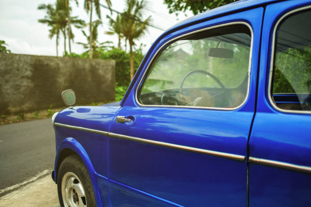istock Side view on retro blue car in tropical city. Palms are on background. 920345152