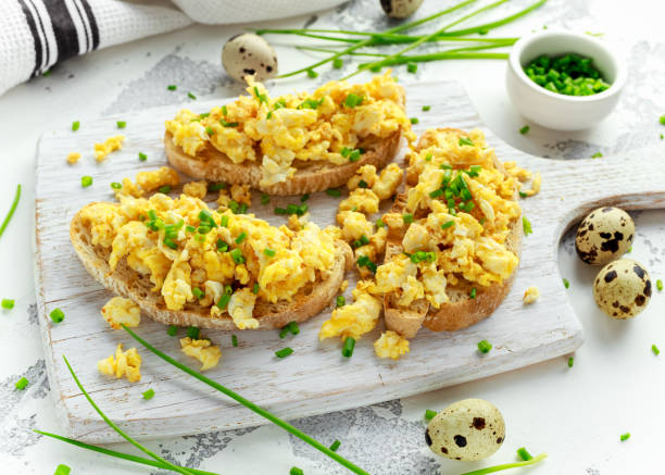 Homemade Quail Scrambled eggs on crispy toast, bread with green onion, chives on white board
