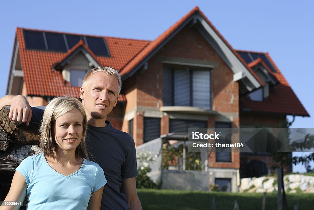 Jeune couple devant leur maison - Photo de Devant libre de droits