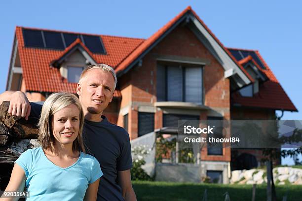 Photo libre de droit de Jeune Couple Devant Leur Maison banque d'images et plus d'images libres de droit de Devant - Devant, Maison, Maison individuelle