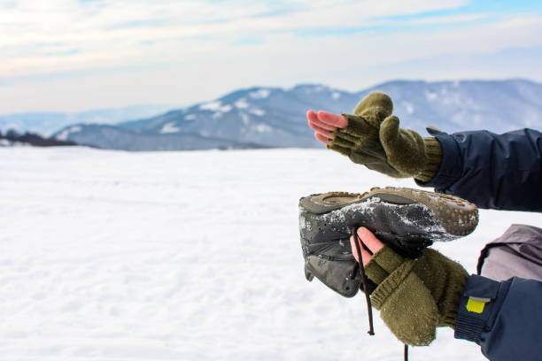 istock Man removing snow from his shoe on a hiking trip 920356720