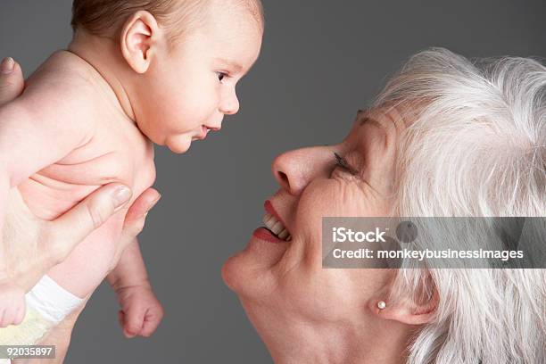 Woman Smiling And Looking Into The Eyes Of A Baby Stock Photo - Download Image Now - Baby - Human Age, Grandmother, Senior Adult