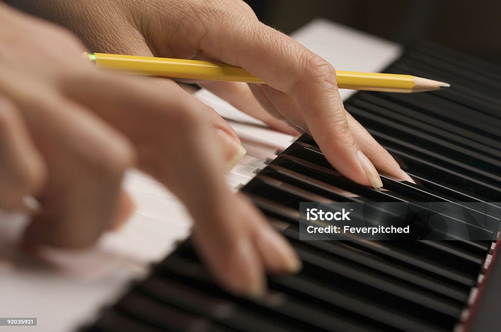 Woman's Fingers with Pencil on Piano Keys  Abstract Stock Photo