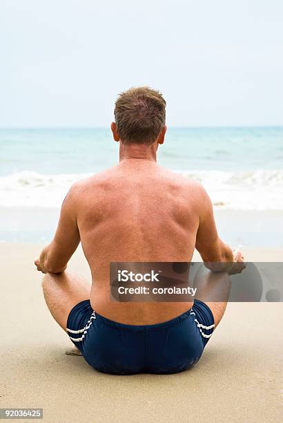 Homem Meditar Na Praia - Fotografias de stock e mais imagens de Vista Traseira - Vista Traseira, De Pernas Cruzadas, 40-44 anos