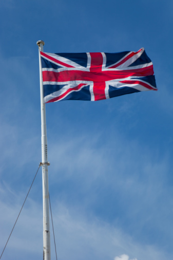 The national flag of United Kingdom, Europe floating in the wind over blue sky