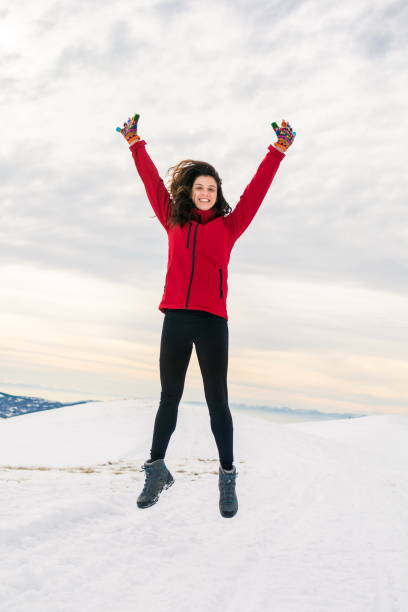 istock Happy girl jumping on snow covered mountain top 920371034