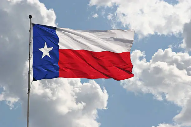 Photo of The Texas state flag flying on a beautiful day