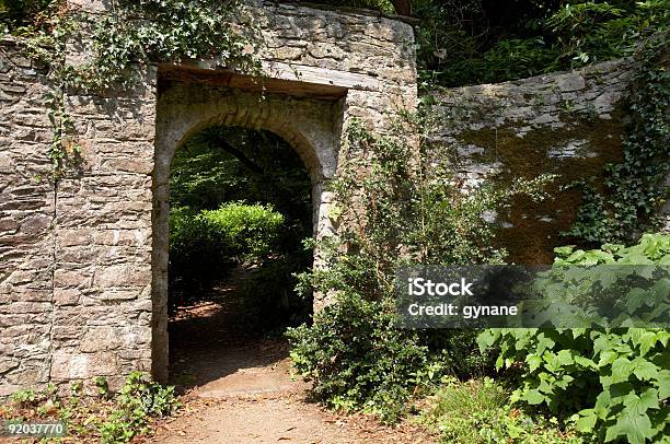 Puerta A Través De Un Verde Exuberante Jardín Foto de stock y más banco de imágenes de Abrir - Abrir, Aire libre, Aislado