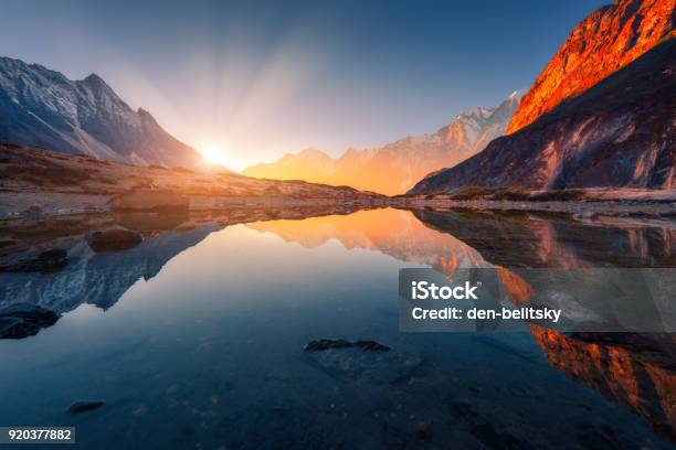 Beautiful Landscape With High Mountains With Illuminated Peaks Stones In Mountain Lake Reflection Blue Sky And Yellow Sunlight In Sunrise Nepal Amazing Scene With Himalayan Mountains Himalayas Stock Photo - Download Image Now