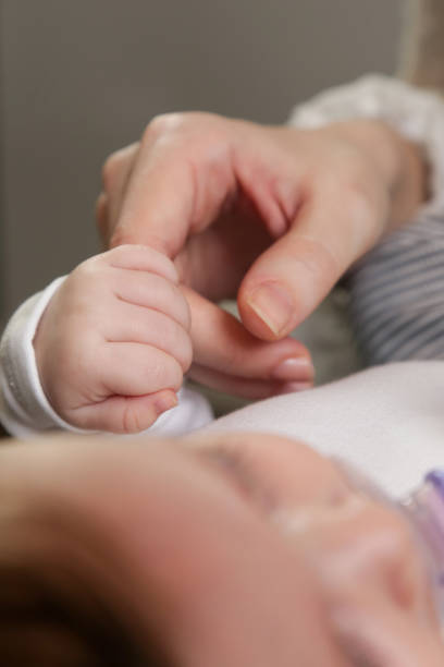 istock Newborn baby holding mother's finger 920381322