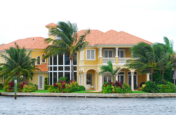 Waterfront mansion with palm trees Ultra expensive oceanfront home in exclusive Palm Beach neighborhood canal photos stock pictures, royalty-free photos & images