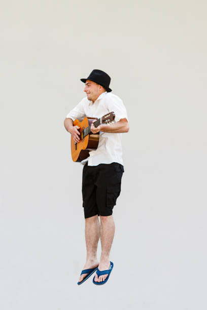 istock Man in sun hat jumping with guitar 920402284