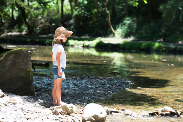 istock Little girl playing on a stream 920402304