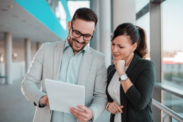istock Cheerful business people discussing documents in office hall. 920405748