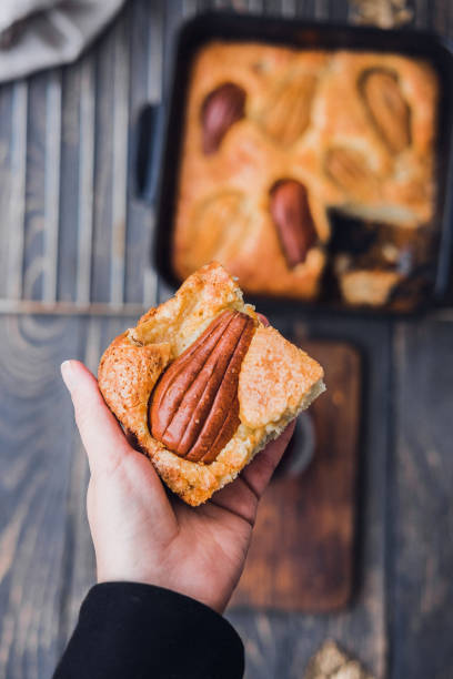 Woman's hand holding piece of pear cake