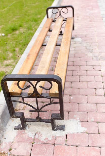 istock bench on the pavement in the park 920418242