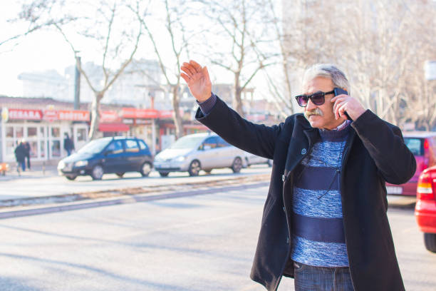 istock Elderly man in a hurry calling a taxi 920424814