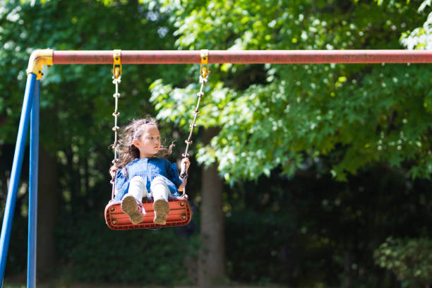 istock Little girl playing with a swing 920427510
