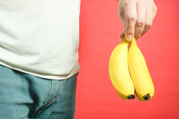 istock The banana which is held by a hand. red background 920427646