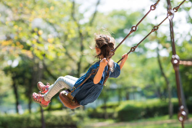 istock Little girl playing with a swing 920430128
