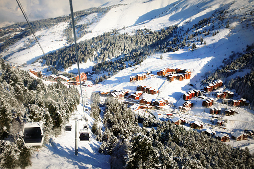 A mountain village Meribel-Mottaret. Skilift cabin view. Three Valleys, France. Winter skiing resort . Cold season sport activity for family. Vacation and recreation concept.