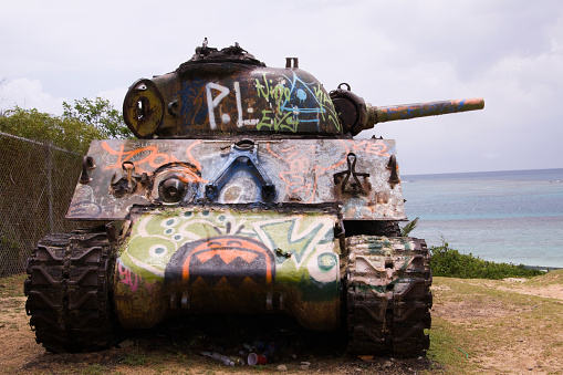 Tank with graffiti with remnants of a party. Blue sea in background. Culebra, Puerto Rico.