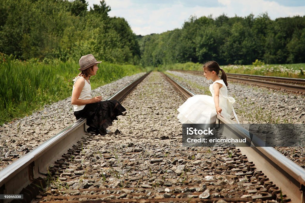 Due ragazze seduto su una ferrovia - Foto stock royalty-free di 10-11 anni