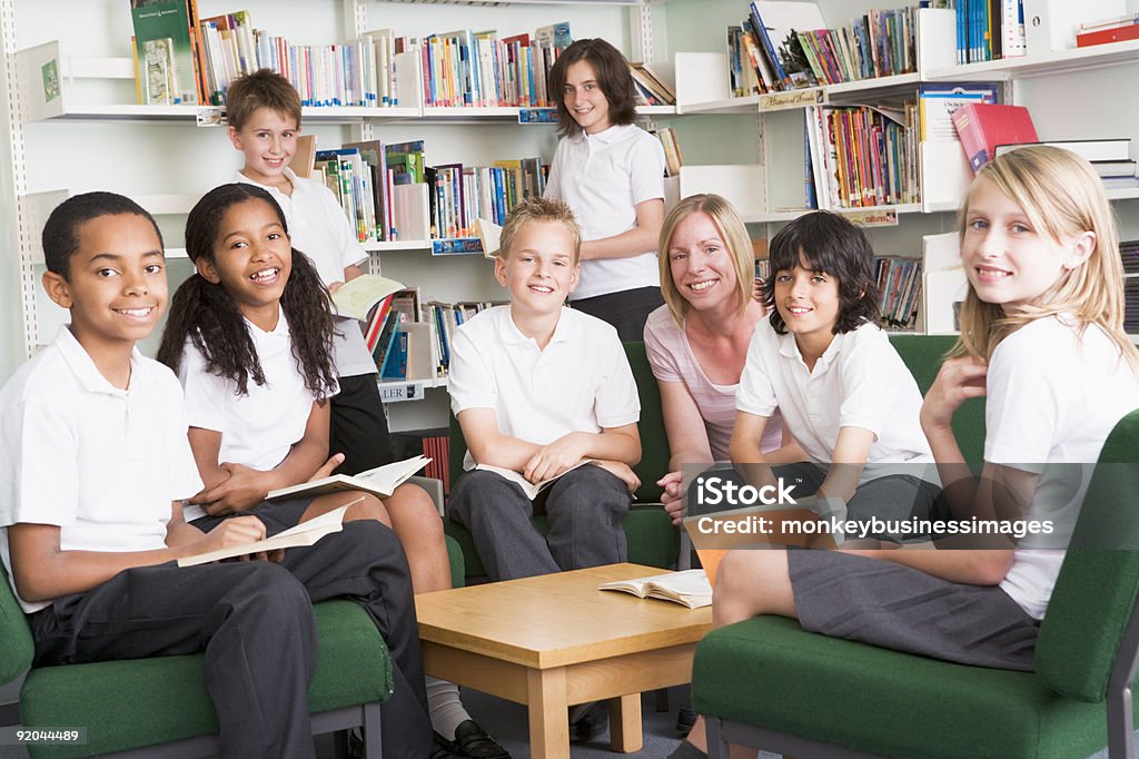 Junior estudiantes trabajando en la biblioteca de la escuela - Foto de stock de 10-11 años libre de derechos