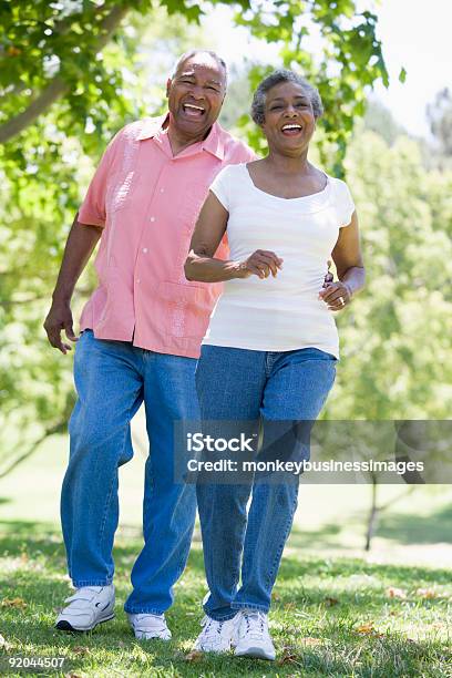 Senior Couple Having Fun In Park Stock Photo - Download Image Now - Senior Adult, Exercising, Walking