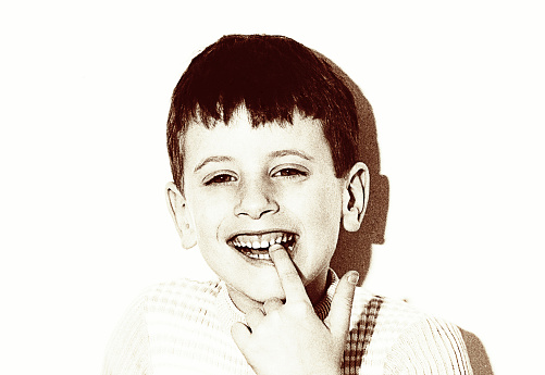 vintage grainy portrait of a boy laughing to camera on white background.