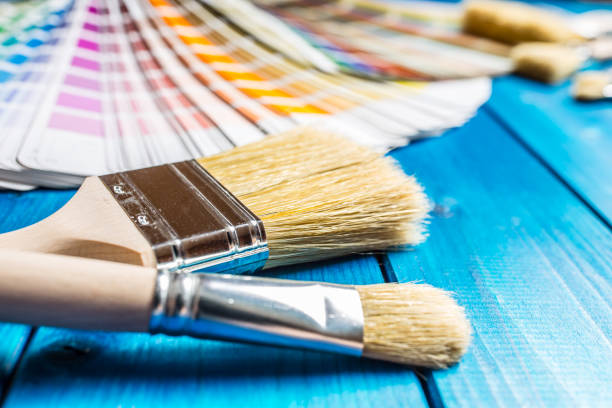 istock Paint cans color palette, cans opened with brushes on blue table 920449262