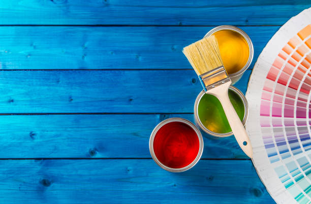 istock Paint cans color palette, cans opened with brushes on blue table 920449274
