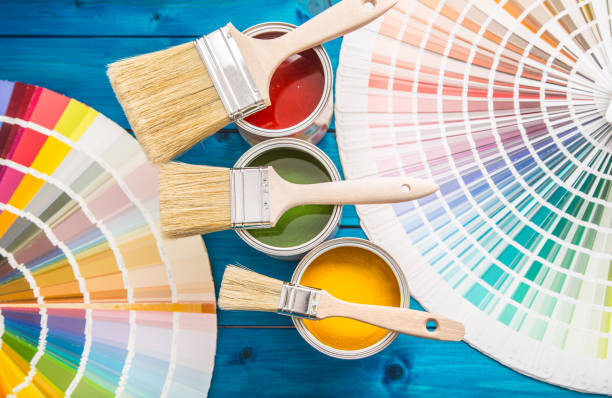 istock Paint cans color palette, cans opened with brushes on blue table 920449280