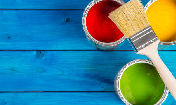 istock Paint cans color palette, cans opened with brushes on blue table 920449288
