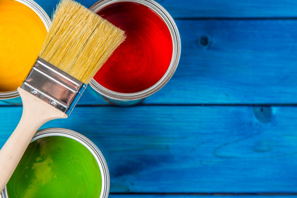 istock Paint cans color palette, cans opened with brushes on blue table 920449298
