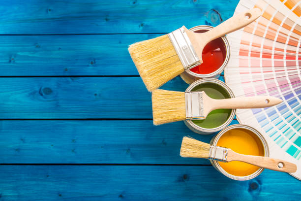 istock Paint cans color palette, cans opened with brushes on blue table 920449310
