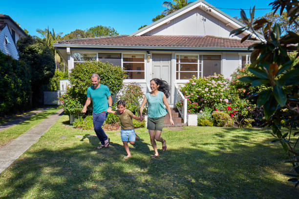 istock Happy family holding hands while running in lawn 920461776