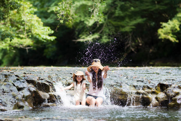 istock Mother and daughter playing in mountain stream 920462312