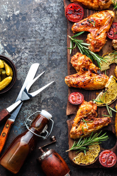 istock appetizing chicken wings grilled barbecue with spices and vegetables until crisp, top view, space for text 920465492