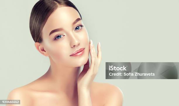 Gorgeous Blueeyed Young Woman With Clean Fresh Skin Is Touching Own Face Light Smile On The Perfect Face Cosmetology Stock Photo - Download Image Now