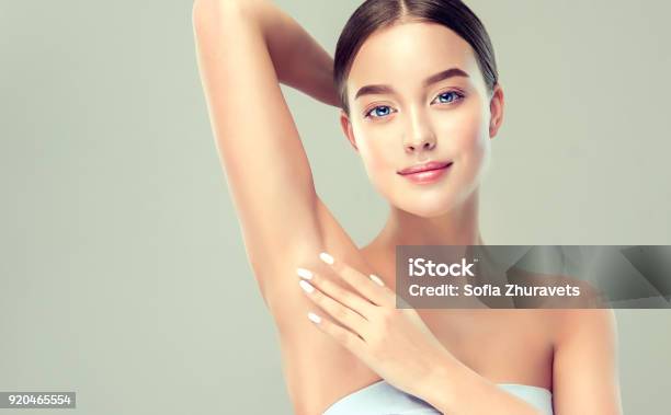 Young Blueeyed Woman Is Holding Her Arm Up And Showing Clean Underarm Cosmetology And Armpit Epilation Cosmetology Stock Photo - Download Image Now