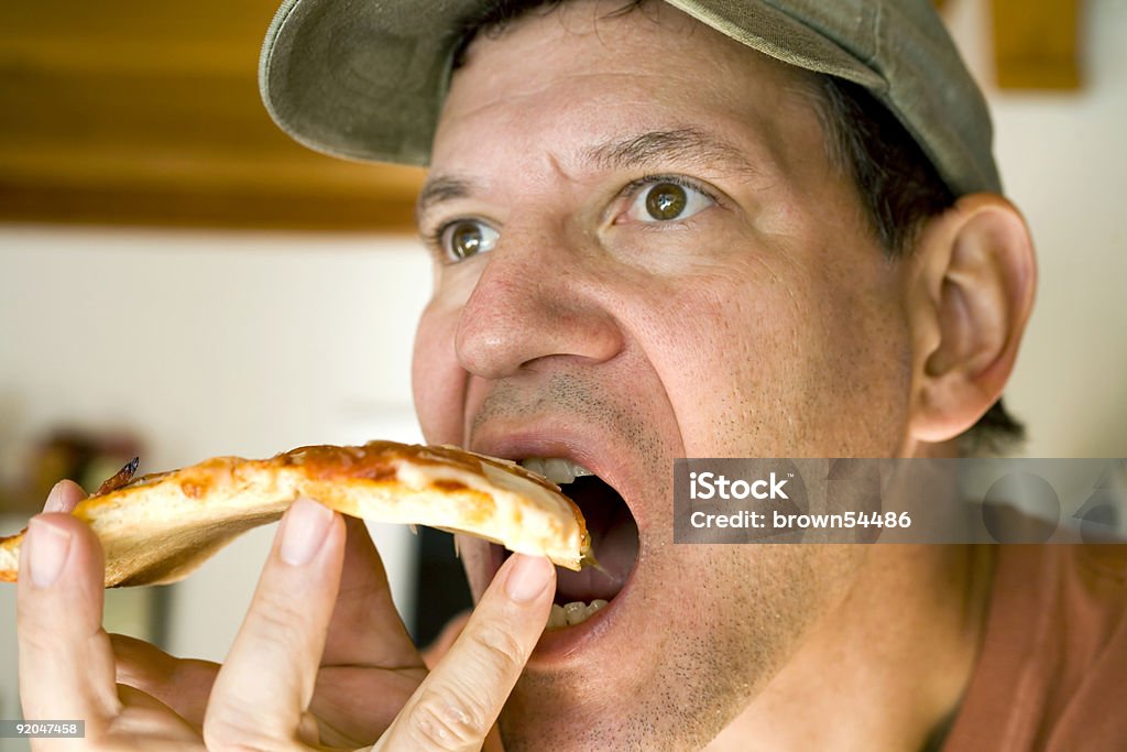 Uomo mangiando Pizza alla salsiccia piccante - Foto stock royalty-free di Formaggio