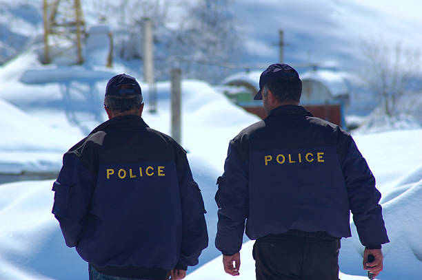 Helsinki, Finland - April 16, 2011: Two finnish policemen keep order near the police car on Aleksanterinkatu street next to The Stockmann Department Store in the center of capital.