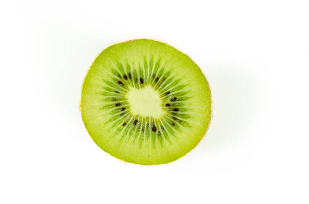 istock Fresh green kiwi fruit slice close up partially isolated on white background with selective focus, view from above 920478574