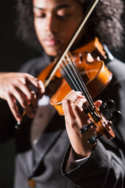 istock Mixed race teenage boy playing the violin 920479470