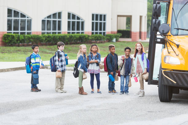 istock Elementary school children waiting outside bus 920484962