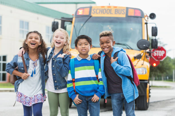istock Elementary children standing in front of school bus 920485572